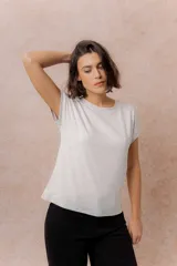 Remera básica color celeste, de corte relajado, cuello redondo y mangas cortas con hombro caído y dobladillo.
