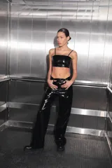 Pantalón negro de charol con tiro medio alto, botón metálico níquel, badana de RENÉE en cintura y bolsillos traseros.