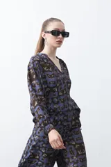 Blusa de manga larga con cuello en V y estampado abstracto en tonos azul y marrón oscuro.