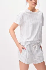 Pijama de algodón compuesto por una remera de manga corta con cuello redondo y un short con cordón ajustable en la cintura, ambos con diseño de rayas verticales formadas por pequeños motivos florales en tonos azules sobre fondo blanco.