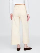 Jean de corte recto y tiro alto, con diseño tipo utility que incluye bolsillos frontales de parche y ruedo con dobladillo ancho. Presenta costuras a la vista en tono contrastante.