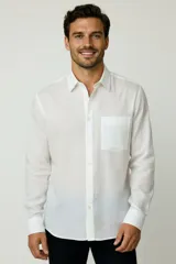 Camisa de corte holgado, color blanco, con cuello clásico, cierre frontal de botones y bolsillo en el pecho.