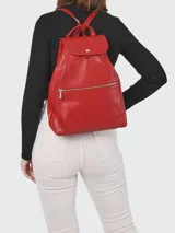 Mochila de cuero color rojo con cierre de cremallera frontal y solapa con broche a presión.