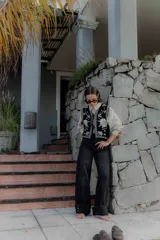 Pantalón de jean negro de corte recto y tiro alto, con detalle de botones en el dobladillo de la pierna.