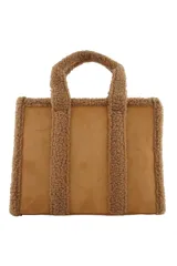 Cartera tipo tote de Las Oreiro, confeccionada en gamuza sintética color beige con detalles de corderito en los bordes y manijas. Incluye un parche frontal con el logo de la marca y correa ajustable extraíble.