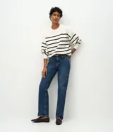 Pantalón de jean azul, de corte recto y tiro medio, con bolsillos funcionales, trabillas para cinto y cierre frontal con cremallera y botón.
