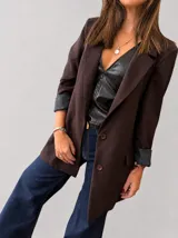 Blazer sastrero color marrón chocolate, de corte clásico con hombreras, botones frontales y bolsillos funcionales. Cuenta con forrería interna y mangas con vuelta.