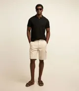 Bermuda cargo para hombre en color beige, confeccionada en algodón con un toque de elastano. Presenta bolsillos laterales utilitarios, cierre de botón y cremallera, y trabillas en la cintura.
