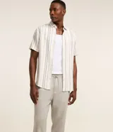 Pantalón masculino relaxed fit confeccionado en oxford de algodón, color beige, con trabillas en la cintura y cordón ajustable con lazo. Cuenta con bolsillos delanteros y traseros.