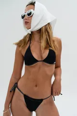 Bottom de bikini tipo tanga color negro con costuras blancas contrastantes y tiras ajustables para atar a los lados.