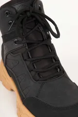 Zapatilla tipo hiking de caña media, confeccionada en una combinación de símil cuero y nylon en tonos beige y rosa suave. Presenta cordones al tono, interior acolchado para mayor abrigo y suela de goma dentada en color marrón con entresuela gris.