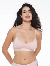 Top deportivo tipo bralette negro, con escote en V y tirantes finos cruzados en la espalda. Presenta una banda elástica ancha bajo el busto con texto repetido.