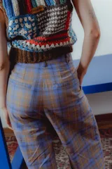 Pantalón de vestir a cuadros azul y marrón, de corte recto con pinzas en la cintura.