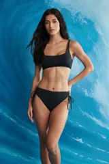 Conjunto de bikini negro de dos piezas con corpiño de escote cuadrado y tirantes finos, y bombacha vedetina con tiras laterales ajustables.