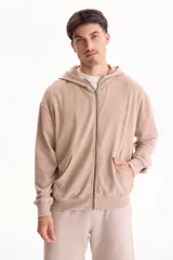 Campera con capucha y cierre frontal, color beige con efecto lavado stone wash, bolsillos tipo canguro y corte oversize.