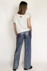 Pantalón de corte recto y tiro alto, confeccionado en tela plisada con acabado metalizado brillante en tono azulado. Presenta cintura elástica para mayor comodidad y ajuste.