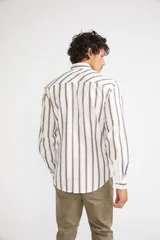 Camisa de manga larga con cuello clásico y cierre frontal abotonado. Presenta un estampado de cuadros en tonos azul marino y rojo. Confeccionada en algodón, cuenta con un corte slim fit y logo bordado en el pecho.