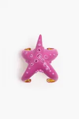 Pulsera rígida color fucsia con forma de estrella de mar y apliques de strass rosados.
