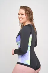 Body de surf negro con cierre frontal y paneles laterales estampados con diseño geométrico en tonos celeste, lila, rosa y naranja.