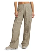 Pantalón cargo Under Armour modelo Unstoppable Woven Utility, color beige, de corte holgado confeccionado en tejido técnico ripstop ultrarresistente con acabado brillante. Cuenta con cintura elástica con bragueta y botón a presión, bolsillos laterales con cremallera, bolsillos traseros abiertos, bolsillo cargo y cordón elástico en los puños para ajustar el bajo.