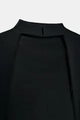 Vestido negro, largo, de cuello perkins y manga sisa, con detalle de espalda descubierta y bajo en línea evasé.