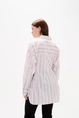 Camisa de viscosa con estampado de rayas verticales, cuello camisero, cierre frontal con botones y detalle de ajuste lateral con cordones.