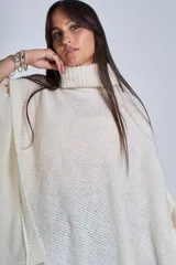 Poncho tejido color beige, con cuello alto y corte asimétrico.