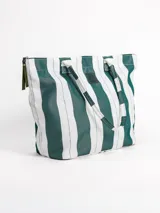 Bolso tipo tote grande, resistente al agua, con diseño de rayas verticales rojas y blancas. Cuenta con asas largas de hombro, cierre superior y parche de cuero con logo grabado. Incluye neceser transparente a juego con base y detalles a rayas.