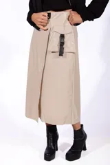 Falda midi color beige de simil cuero, con corte irregular, bolsillo lateral y cinturón con hebilla plástica.