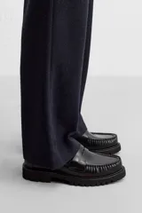 Mocasín de vestir fabricado en piel de alta calidad con detalle de antifaz en el empeine, horma redonda y suela track con ligero volumen.