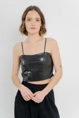 Top crop negro de cuero ecológico con espalda de encaje floral nude, tirantes finos y corte entallado.