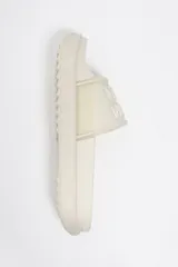 Sandalia tipo pala color blanco crudo, con plataforma, suela dentada y logo en relieve en la tira frontal.