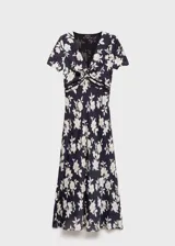 Vestido midi de corte evasé con estampado floral en blanco y negro. Presenta cuello de pico, mangas cortas y detalles de blonda en la cintura.