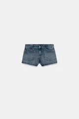 Shorts de jean tiro medio con bolsillos delanteros de plastrón decorados con tachas metálicas. Presenta cierre frontal con cremallera y botón metálico.