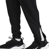 Pantalón deportivo negro Nike Challenger, con cintura elástica, cordón ajustable, bolsillos laterales y puños con cierre.