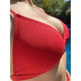 Bikini de dos piezas color rojo, compuesto por un corpiño triangular y una bombacha de tiro alto con diseño tipo tanga. Confeccionado en licra con textura acanalada.