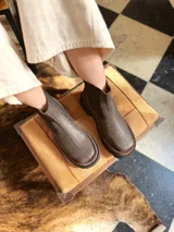 Bota Chelsea de cuero color marrón chocolate con elástico lateral negro y suela track color negro.