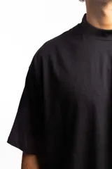 Remera negra de corte boxy con cuello subido y logo bordado en el pecho.