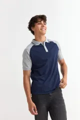 Remera tipo polo de manga corta con diseño combinado, presentando cuerpo en color azul marino y mangas y cuello en color gris. Cuenta con cierre frontal de botones.