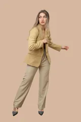 Blazer color camel con solapa entera, cierre de un botón y dos bolsillos delanteros con solapa. Forro estampado con diseño paisley en tonos grises y celestes, visible en los puños al doblarlos.