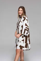 Vestido camisero blanco con estampado de letras marrones, de corte holgado y manga 3/4.