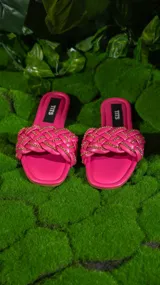 Sandalias negras con tiras trenzadas y cadena dorada.