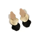 Aros colgantes con tres piezas irregulares de distintos colores: beige, dorado y negro con glitter.