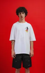 Remera oversize de algodón premium color blanco, con cuello redondo y manga corta. Presenta un pequeño estampado del personaje Mickey Mouse en el lado izquierdo del pecho.