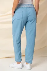 Pantalón celeste de jean italiano de algodón elastizado, corte recto y tiro alto. Incluye cinturón rústico elastizado para ajustar.