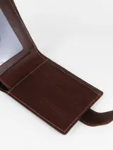 Billetera de cuero marrón, confeccionada en combinación de cuero liso y gamuza, con cierre de presilla y logo grabado en la parte frontal.