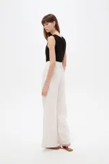 Pantalon sastrero ancho de tiro alto, color beige, con bolsillos y cierre frontal con botón.