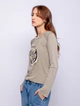 Remera color verde oliva de manga larga con cuello redondo y costuras a la vista. Estampado frontal de un tigre dentro de un círculo.