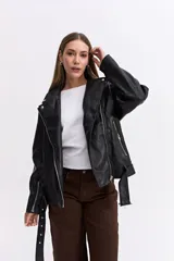 Campera estilo biker de cuero sintético negro con cierre frontal cruzado, solapas amplias, bolsillos con cierre y cinturón ajustable en la base.