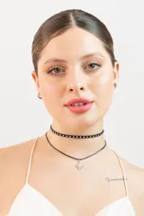 Set de dos gargantillas negras, una con tachas plateadas y otra con dije de estrella plateada.